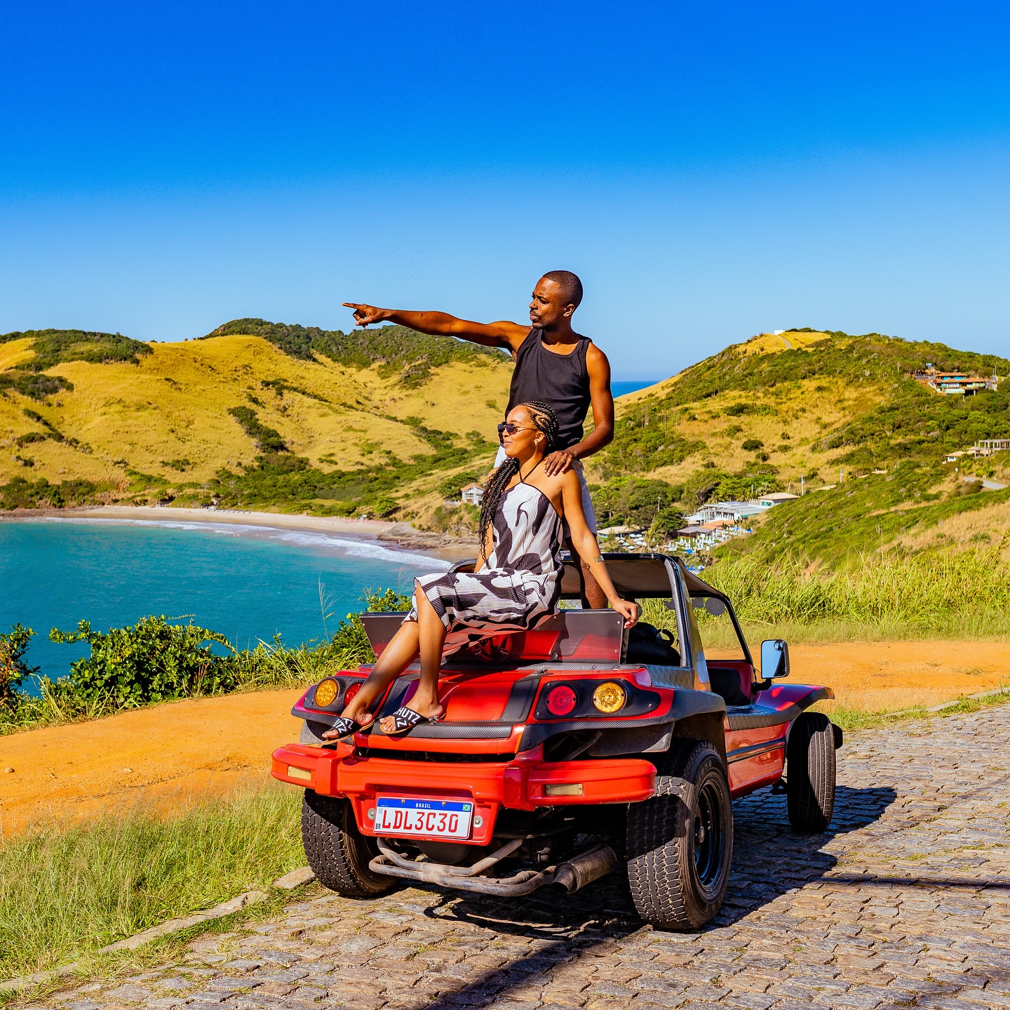 Buggy vermelho em mirante de Búzios com vista para a praia