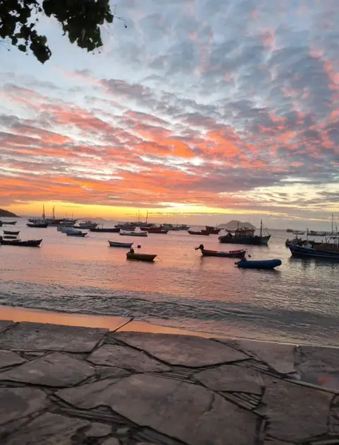 Silhueta de um buggy contra um pôr do sol vibrante em um mirante de Búzios