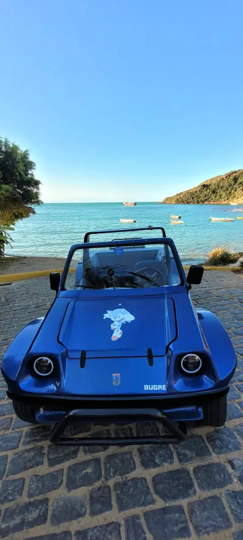 Buggy privativo estacionado em uma praia deserta em Búzios com águas cristalinas ao fundo