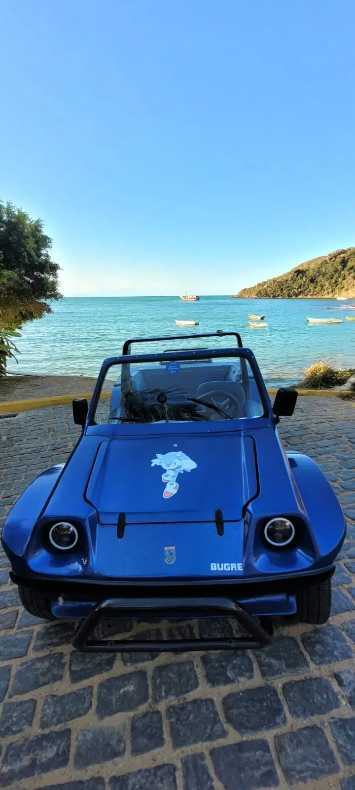 Buggy privativo estacionado em uma praia deserta em Búzios com águas cristalinas ao fundo