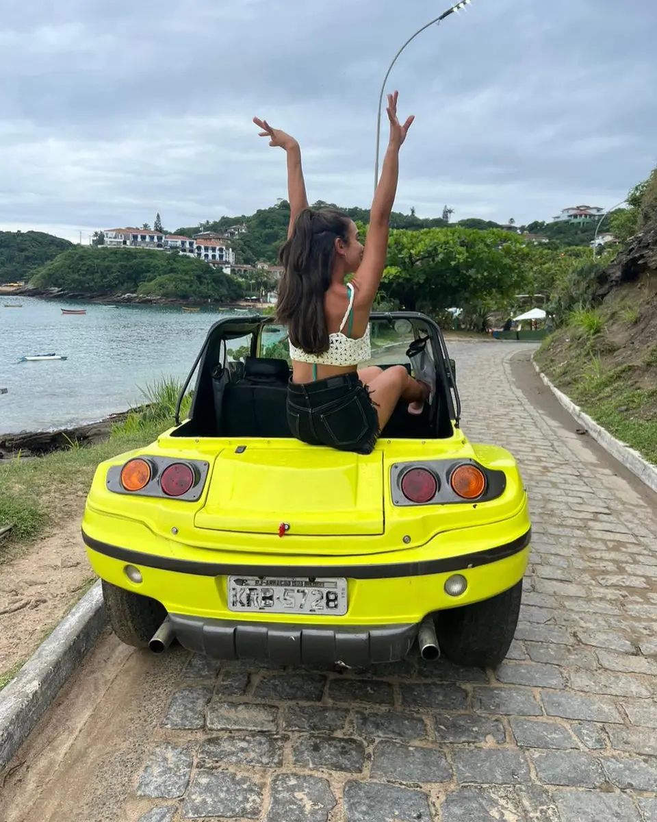 Buggy privativo subindo a ladeira de um mirante em Búzios com facilidade enquanto o trânsito local aparece ao fundo