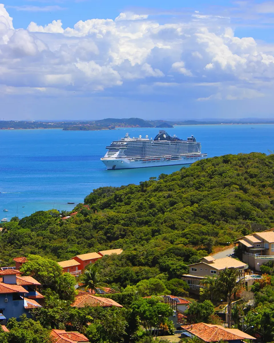 Un buggy privado estacionado frente al mar en Búzios con un barco de crucero visible a lo lejos en el horizonte del océano atlántico
