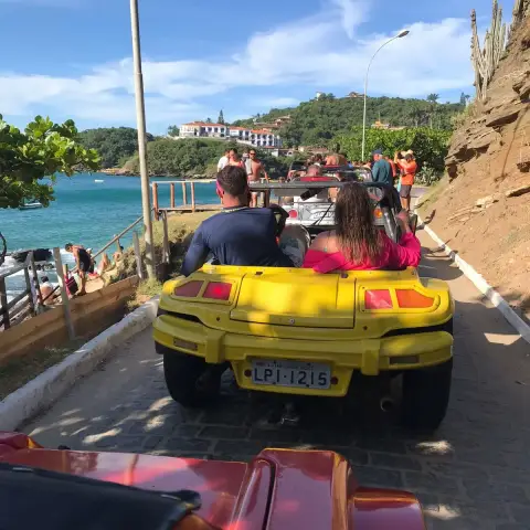 Una familia feliz con niños disfrutando a bordo de un buggy privado descapotable en una playa de Búzios
