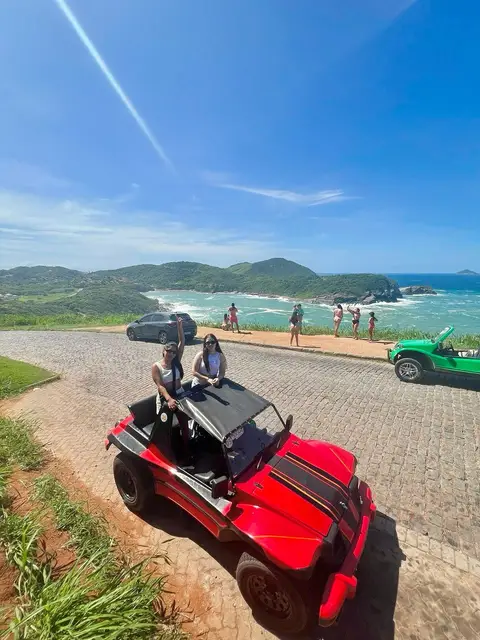 Un buggy de alquiler rosa estacionado frente a la costa de Búzios listo para ser entregado a turistas.