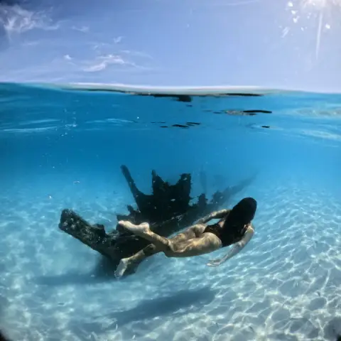 Turistas haciendo snorkel durante un paseo en barco por las aguas cristalinas de Arraial do Cabo desde Búzios.