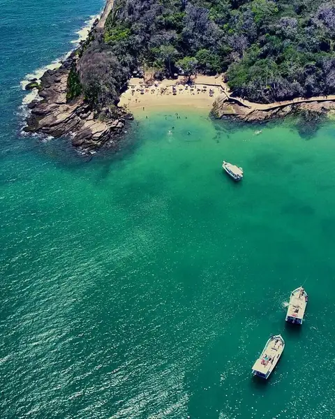 Passengers enjoying the top deck of a scenic boat tour in Búzios Brazil with turquoise water